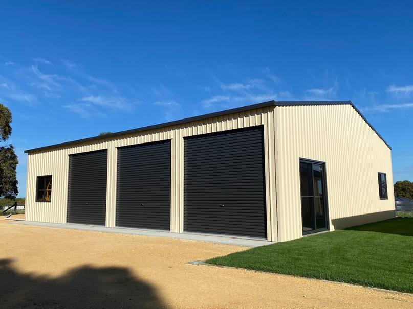 Cream garage with dark roller doors built by Blackbird Industries