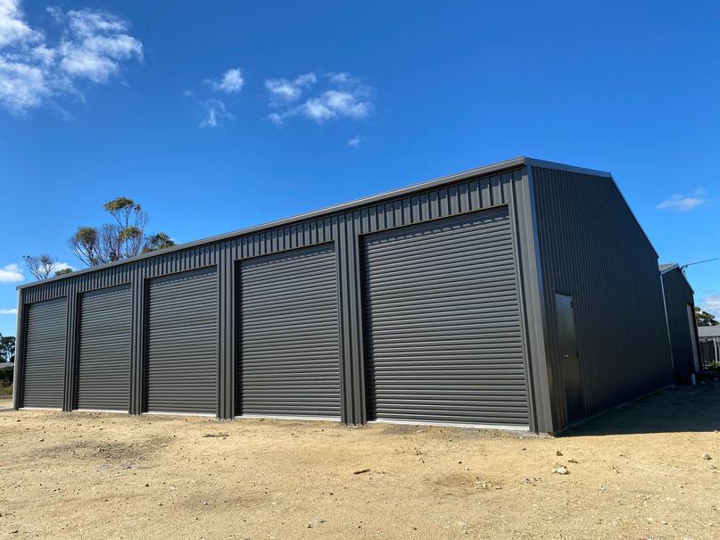Large dark industrial shed with roller doors built by Blackbird Industries